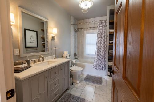 ein Badezimmer mit Waschbecken, Toilette und Spiegel in der Unterkunft Luxury Home w/ Private Patio Mins away from DT RC in Rapid City
