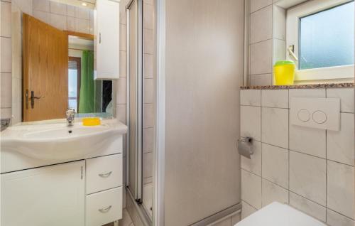 a white bathroom with a sink and a mirror at Cozy Apartment In Crikvenica With Heated Swimming Pool in Crikvenica