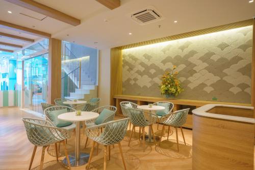 a restaurant with tables and chairs and a large window at Seaesta Nha Trang Hotel in Nha Trang