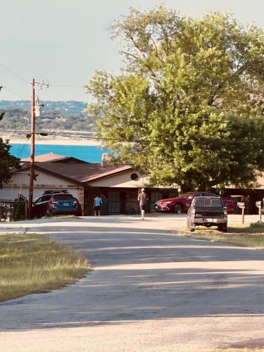 a man walking down a street next to a parking lot at Jet Skis, Lake View, Sleeps 8, HotTub, Firepit, Pet Friendly! in Canyon Lake