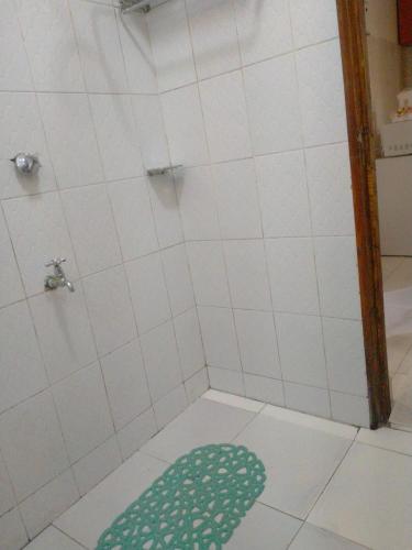 a bathroom with a shower with a green rug on the floor at Tranquil Homes in Nanyuki