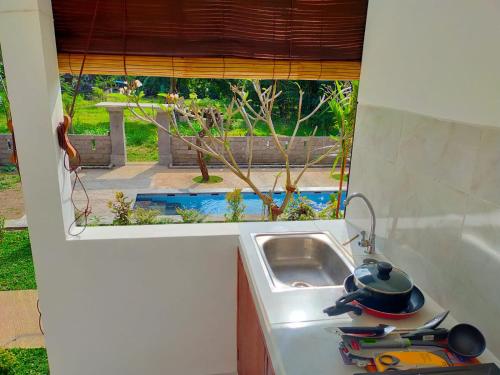 un comptoir de cuisine avec un évier et une fenêtre dans l'établissement OkaOki Homestay, à Amed