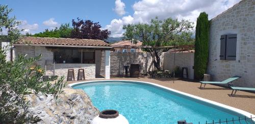 a swimming pool in front of a house at le coin de paradis in Modène