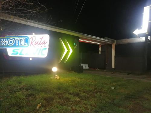 a motel sign on the side of a building at night at Motel ruta slavic in Punta Arenas