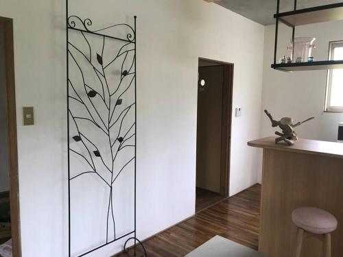 a glass door with a tree design on it in a kitchen at 大自然の一軒家。便利社会からの逃避、究極のセルフ山小屋ライフ in Madarao Kogen