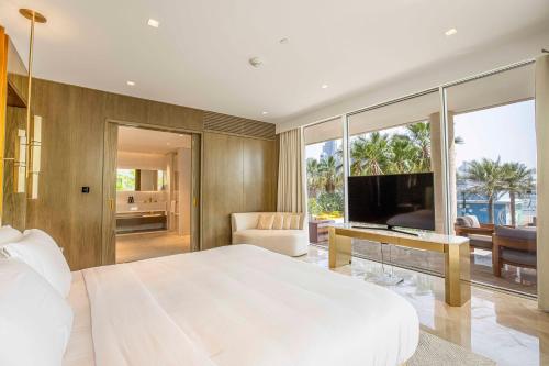 - une chambre avec un grand lit blanc et une télévision dans l'établissement FIVE PALM 3-Bedroom Villa with Private Pool, à Dubaï