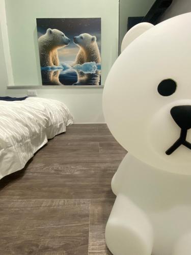 a bedroom with a bed and a polar bear picture at 漫光時旅民宿-電子入住 in Taitung City