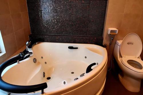 La salle de bains est pourvue d'une baignoire et de toilettes. dans l'établissement KLCC Luxurious 2 Floors Homestay 5BR for 15pax, à Kuala Lumpur