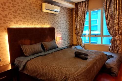 - une chambre avec un grand lit et une fenêtre dans l'établissement KLCC Luxurious 2 Floors Homestay 5BR for 15pax, à Kuala Lumpur