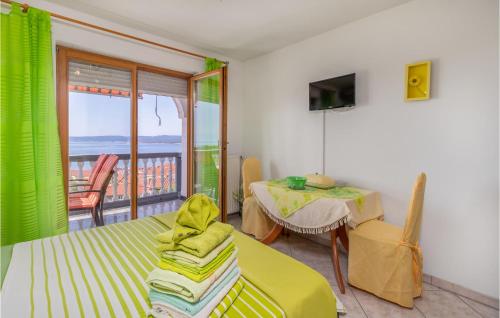 a room with a bed and a table and a balcony at Cozy Apartment In Crikvenica With Heated Swimming Pool in Crikvenica