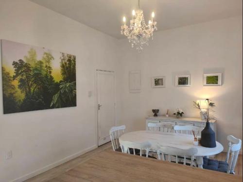 a dining room with a table and chairs and a chandelier at Beautiful villa near everything! in Christchurch