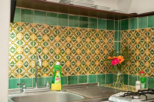 La salle de bains est pourvue d'un lavabo et d'un mur carrelé vert. dans l'établissement Casita La Pila, à Antigua Guatemala