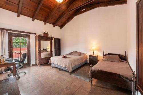 una camera con 2 letti, una scrivania e uno specchio di Casita La Azotea a Antigua Guatemala
