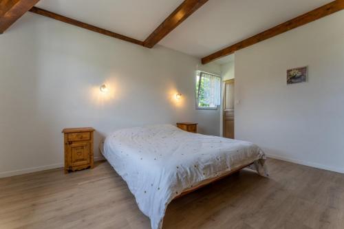 een slaapkamer met een bed en een houten vloer bij Gite 2 pièces Parc des Chamois piscine chauffée in La Châtelaine