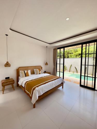 a bedroom with a large bed and a pool at Emma’s Villa in Seminyak