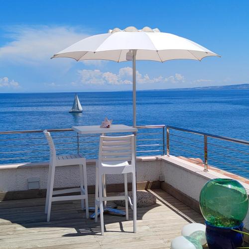 a table and two chairs on a deck with the ocean at B&B alla Canale in Vasto