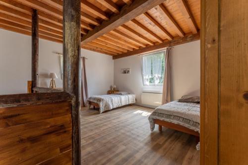 a bedroom with two beds and a large window at Gite Chateau 3 chambres piscine chauffée in La Châtelaine