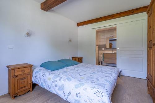 une chambre avec un lit et une commode en bois dans l'établissement Gite Arbois 2 pièces Piscine Chauffée, à La Châtelaine