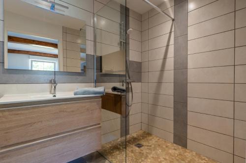 une salle de bain avec un lavabo et une douche dans l'établissement Gite Arbois 2 pièces Piscine Chauffée, à La Châtelaine