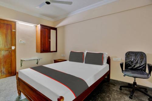 a bedroom with a bed and a chair at Family Castle Inn in Trivandrum