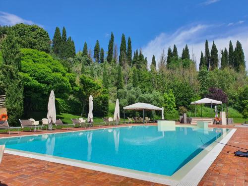 ein großer Pool mit Stühlen und Sonnenschirmen in der Unterkunft Hotel Antica Tabaccaia Resort in Terranuova Bracciolini