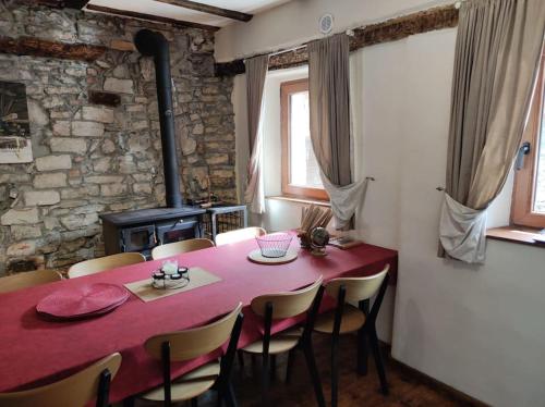 a dining room with a red table and chairs at Casa di Volce - 1801 Stone House in Tolmin
