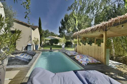 een zwembad in een achtertuin met een huis bij La villa du Petit Bois in Lignan-de-Bordeaux