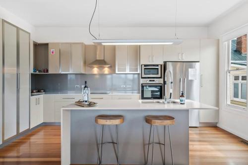 a kitchen with a counter and stools in it at Stunning newly renovated home in perfect location in Hobart