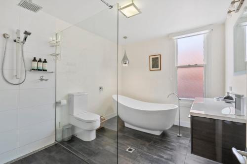La salle de bains est pourvue d'une baignoire, de toilettes et d'un lavabo. dans l'établissement Stunning newly renovated home in perfect location, à Hobart