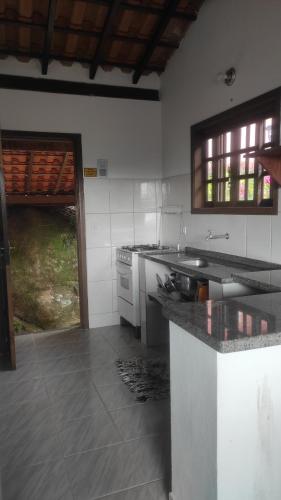 uma cozinha com um lavatório e uma bancada em Chalés Carioca Prumirim Ubatuba em Ubatuba