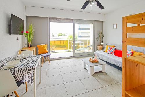 a living room with a couch and a table at Studio moderne avec parking et piscine- 313 in Canet-en-Roussillon