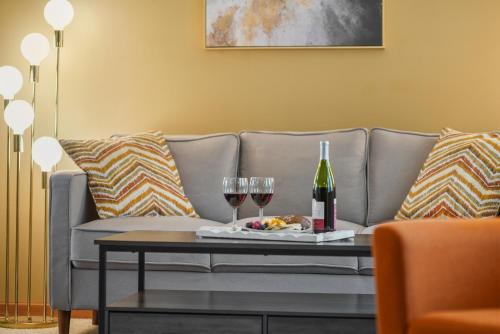a couch with two glasses of wine and a tray of food at LONG LAKE RETREAT- Hot tub, Pool table, Firepit in Traverse City
