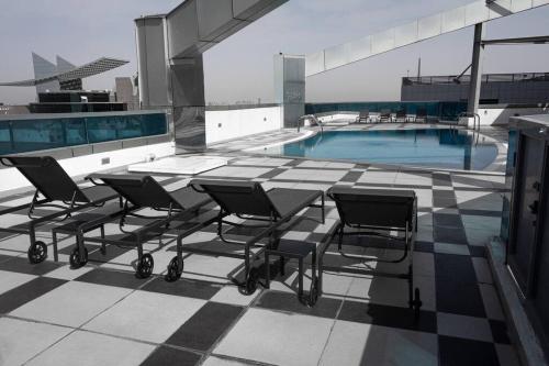 a group of chairs sitting on top of a building with a pool at Super 2 Bedroom Sea Front (City View) in Abu Dhabi