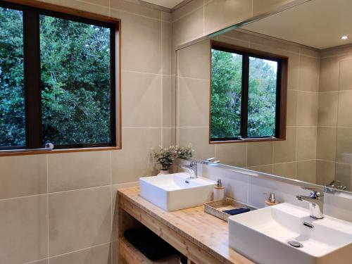a bathroom with two sinks and two windows at Large, Comfy, Stylish Apartment in Havelock North