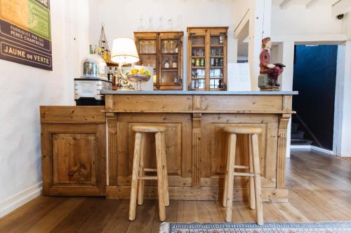a wooden bar in a room with two stools at Coeur des Neiges in Saint-Gervais-les-Bains