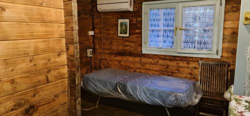 Campeggio Bungalow Darwin في أليميني: غرفة نوم مع مرتبة في غرفة مع نافذة