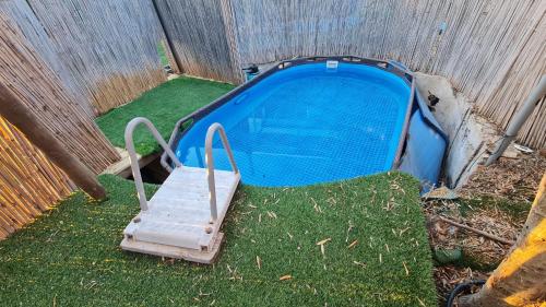 a blue object sitting in the grass next to a fence at Two Snales in Ani'am