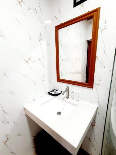 a white bathroom with a sink and a mirror at Areeya phubeach resort wooden house Coliving Coworking in Ban Chong Phli