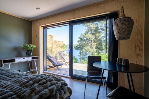 a bedroom with a bed and a table and a large window at Lekkert gjestehus ved sjøen 