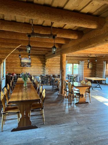 a dining room with wooden tables and chairs at Viesu nams Vālodzes in Sigulda