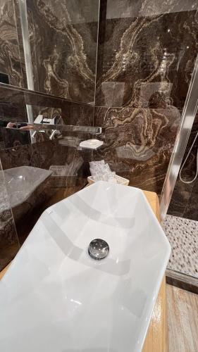 a white toilet in a bathroom with a stone wall at Suites Matteotti 57 in Civitavecchia