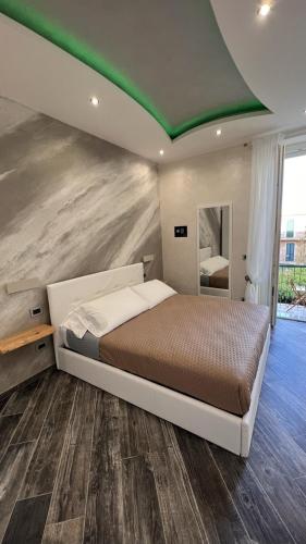 a bedroom with a large bed with a green ceiling at Suites Matteotti 57 in Civitavecchia