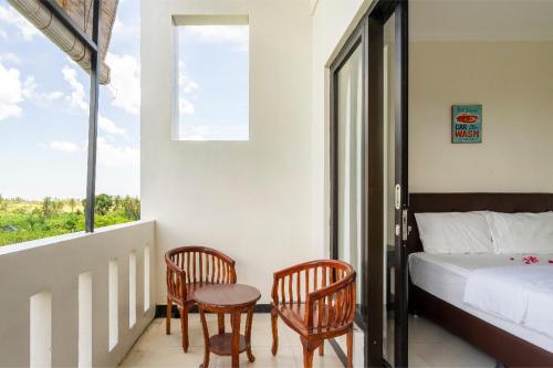 um quarto com uma cama, 2 cadeiras e uma janela em OrangeDacha em Canggu