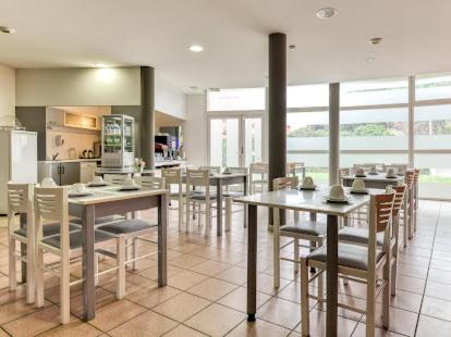 een eetkamer met tafels en stoelen in een keuken bij Studio residence de tourisme le Fonserane in Béziers