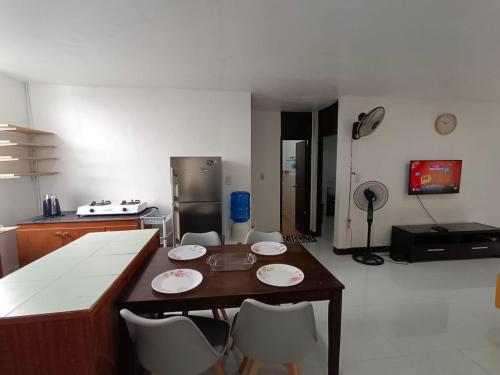 uma cozinha com uma mesa e cadeiras e um frigorífico em Three-Bedroom Holiday Home - 4th Floor Stairs Only em Mactan