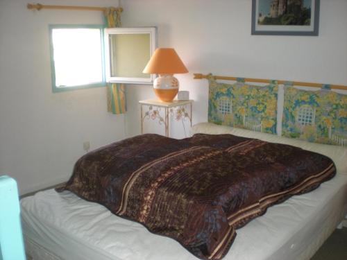 une chambre avec un lit avec une couverture dessus dans l'établissement Maison de vacances Résidence Agdabella, au Cap d'Agde