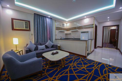een woonkamer met een bank en een tafel bij Quba Inn Hotel in Jazan
