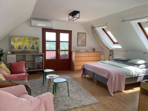 ein Schlafzimmer mit einem Bett und einem Sofa in der Unterkunft Panorama Wine & Chill in Hévíz