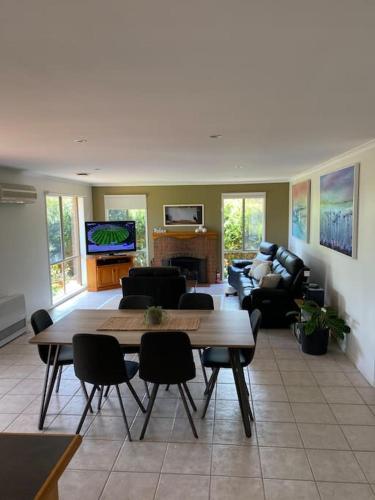 a living room with a table and chairs and a tv at Open 4 bedroom home in Warrnambool