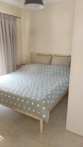 1 cama con sábanas de lunares en un dormitorio en AVRA-2 Apartments Potamos CORFU en Potamós